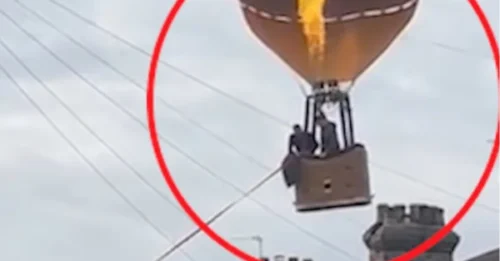 Momento en que un paseador de perros, con su rápida reacción, evita un desastre cuando un globo aerostático se desvía de su curso cerca de una calle residencial.